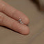 a person's hand holding a tiny silver ring