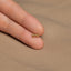 a person's hand holding a tiny gold bow ring