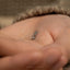 a person's hand with a tiny ring on it