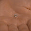 a tiny silver heart charm on a person's hand