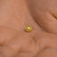 a tiny gold sun on a person's hand