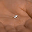 a person's hand holding a tiny silver puzzle piece