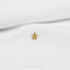 a small gold starfish pin sitting on top of a white sheet