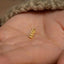 a person's hand with a tiny gold leaf on it