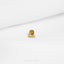 a close up of a small gold object on a white surface
