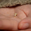 a small gold cross on a person's hand