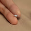 a person's hand holding a tiny silver bird ring