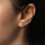 a close up of a person's ear wearing a gold earring