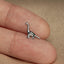 a small dinosaur shaped ring sitting on top of a person's finger