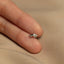 a person's hand holding a tiny silver ring