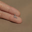 a person's finger with a small silver ring on it