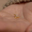 a small gold earring on a person's hand