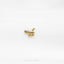 a small gold bird brooch sitting on top of a white surface