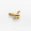 a gold bird brooch sitting on top of a white surface