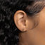 a close up of a person's ear with a gold earring
