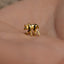 a close up of a person wearing a gold monkey ring