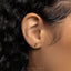 a close up of a person's ear wearing a gold earring