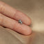 a person's hand holding a tiny silver flower ring
