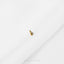 a pair of gold earrings sitting on top of a white sheet