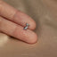 a person's hand holding a tiny silver bird ring