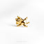 a gold cat brooch sits on a white surface