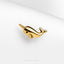a gold whale shaped pin sitting on top of a white surface