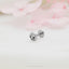a pair of silver earrings sitting on top of a table
