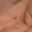 a tiny silver dog pin sitting on top of a person's hand