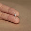 a person's hand holding a tiny silver butterfly ring
