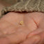 a small gold star of david stud in someone's hand