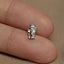 a person's finger with a small silver elephant charm on it