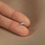 a person's hand holding a tiny silver nose ring