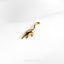 a gold brooch with a dinosaur on it