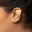 a close up of a person's ear with a single diamond