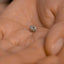 a close up of a person's hand holding a ring
