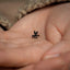 a tiny black object in the palm of someone's hand