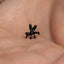 a tiny black toy sitting on top of a persons hand