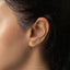 a close up of a woman's ear with a gold stud