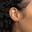 a close up of a woman's ear wearing a gold earring