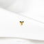 a close up of a white shirt with a gold heart pin