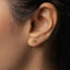 a close up of a woman's ear with a gold stud