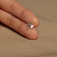 a person's hand holding a tiny silver ring