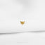 a gold bee pin sitting on top of a white sheet