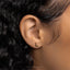 a close up of a person's ear with a gold nose piercing