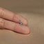 a tiny giraffe shaped ring sitting on top of a person's finger