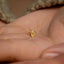 a person's hand holding a tiny gold ring