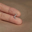 a person's hand holding a tiny bird ring