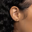 a close up of a person's ear wearing a gold earring