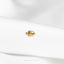a close up of a gold ring on a white shirt