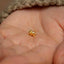 a tiny gold nose piercing on a person's hand